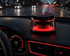solar car diffuser displayed on car dashboard with soft red lighting and aromatic steam rising, enhancing the driving experience.